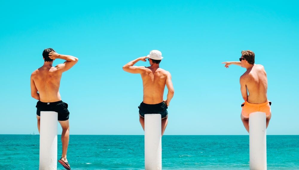 men sitting by ocean on anna maria island