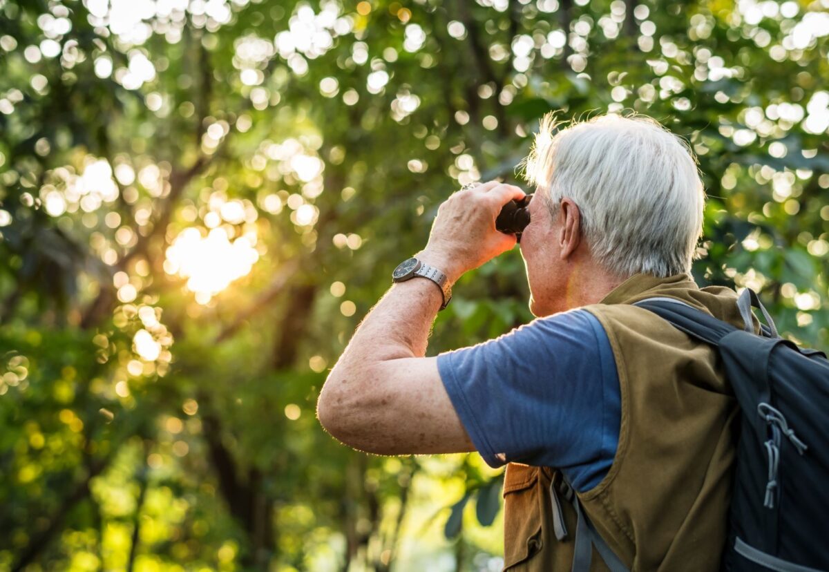 man using binoculars to bird watch