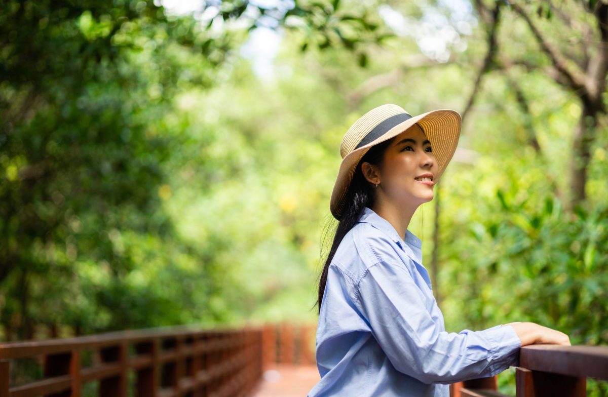 woman in hat enjoying scenic mangrove walk
